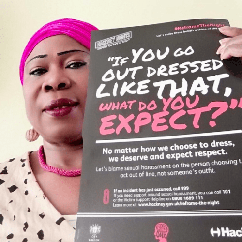 A selfie of Olori Grace holding up a Reframe the Night flyer to the camera.